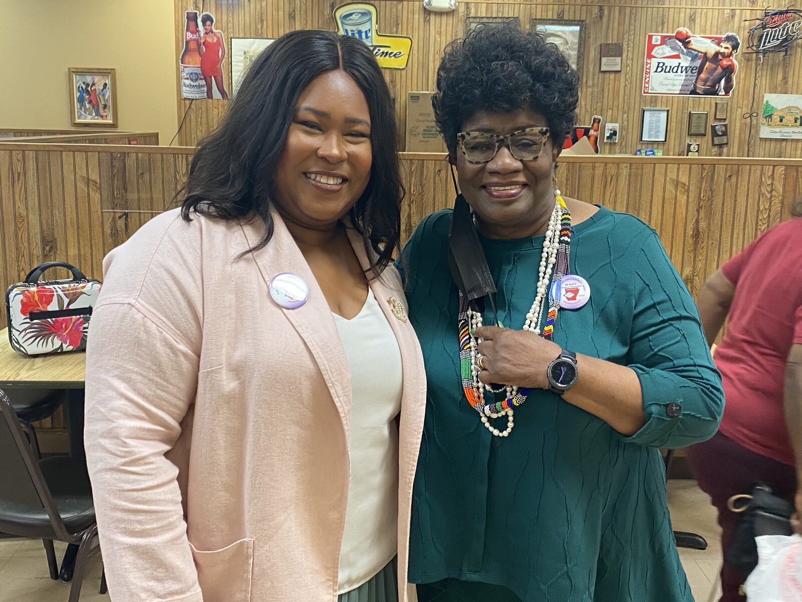 Natalie James with a community elder wearing campaign buttons at a neighborhood gathering