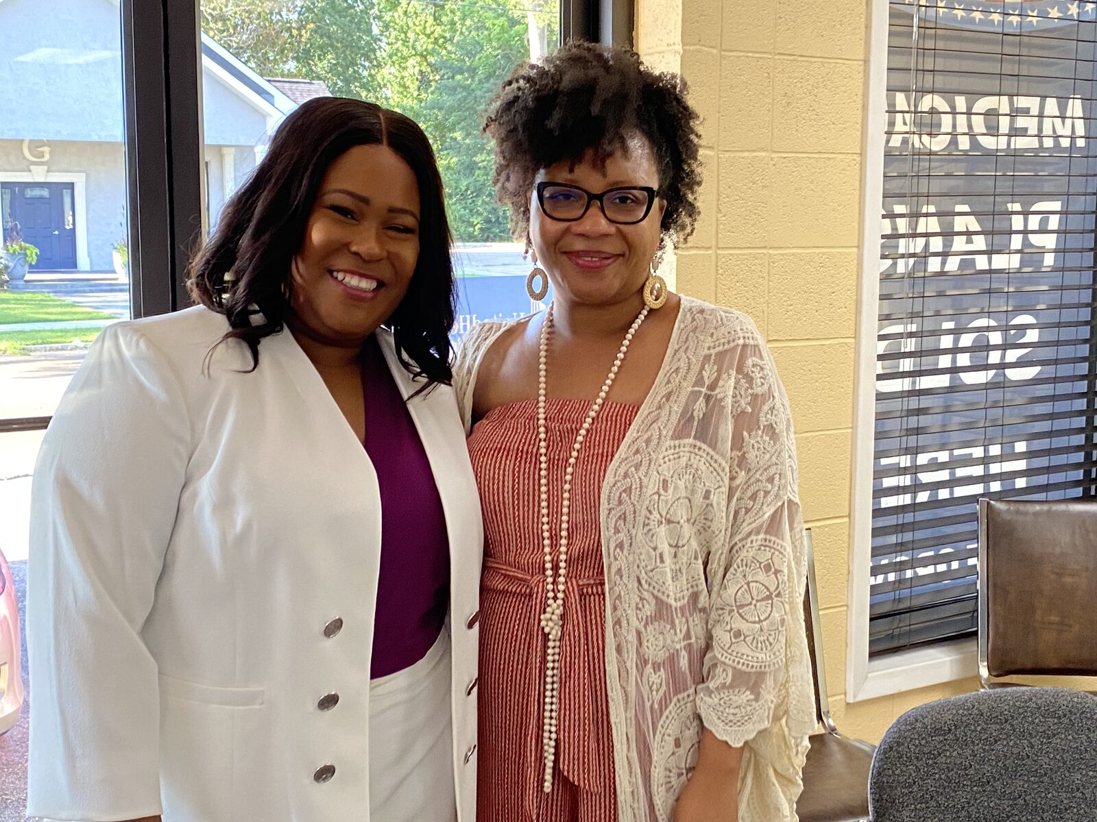 Natalie James with a colleague at a Little Rock real estate office in front of a sold sign